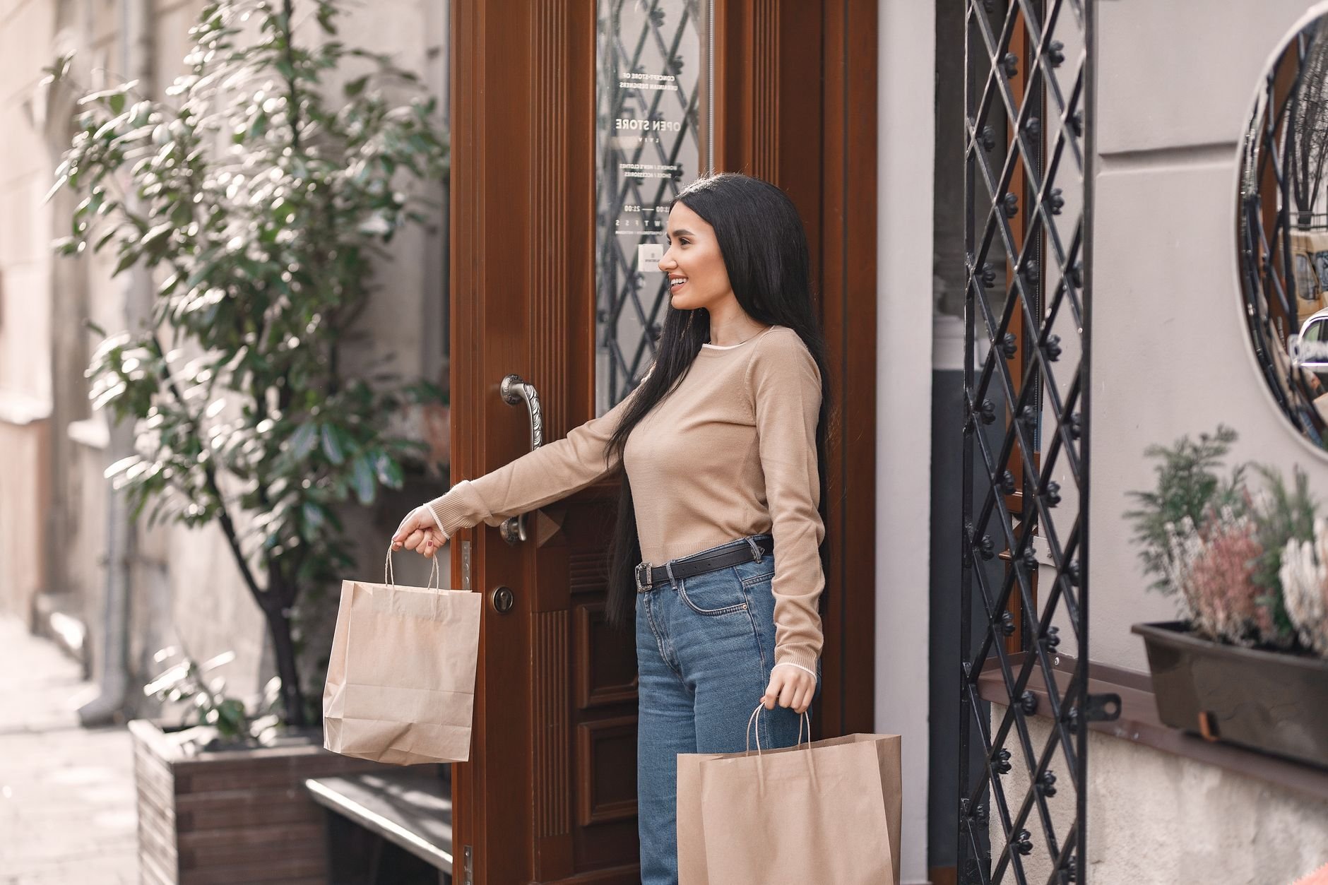 Friendly woman carrying paper shopping bags, ready to help with errands.